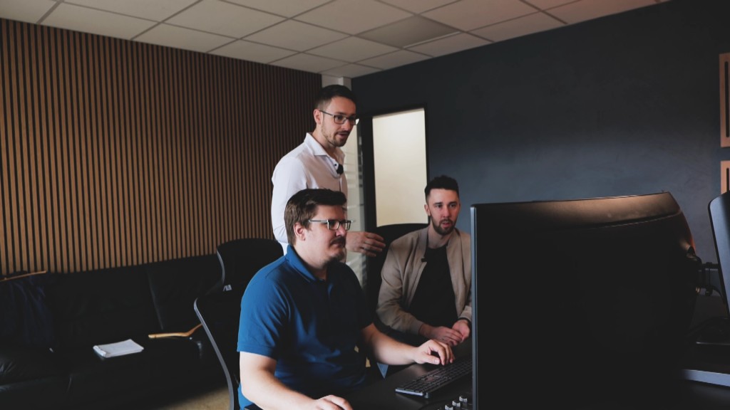 Foto: Drei Männer vor einem PC