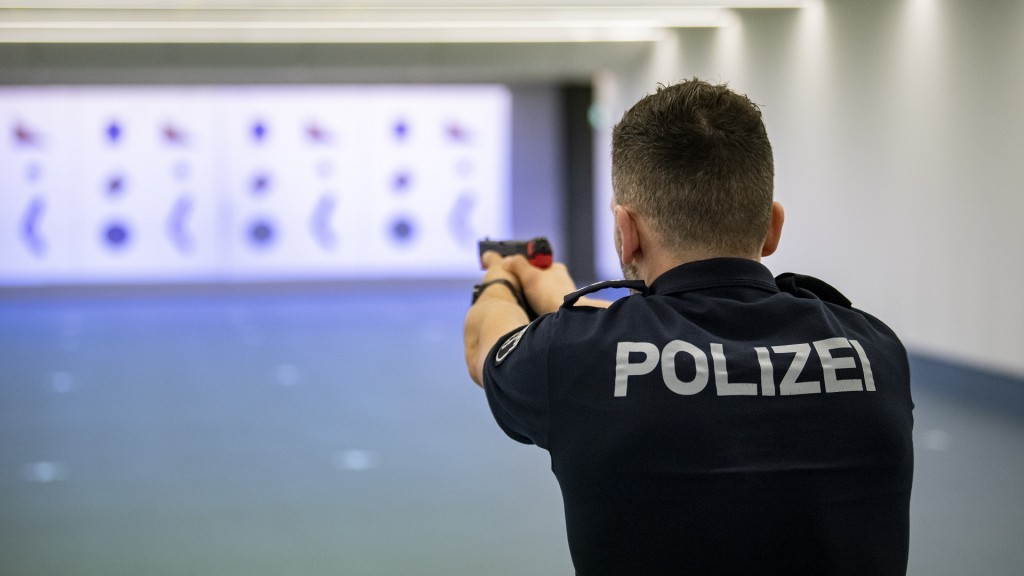 Foto: Ein Polizist steht mit einer Übungswaffe im Schießstand