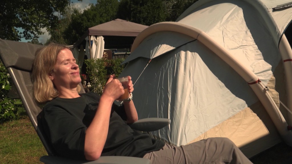 Foto: Frau sonnt sich vor Zelt